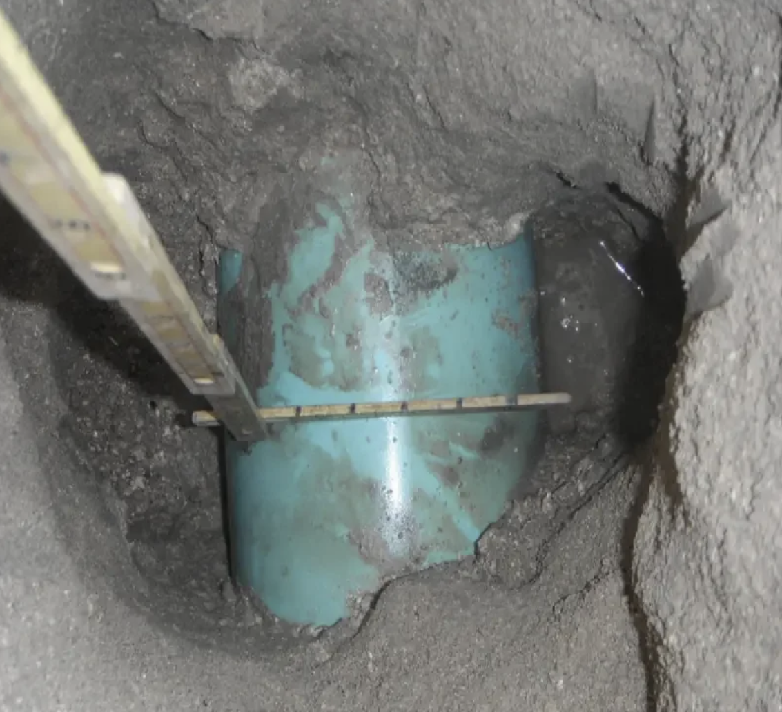 Exposed blue PVC water main in vacuum excavation test hole with measurement ruler — underground pipe mapping QL-A South Florida